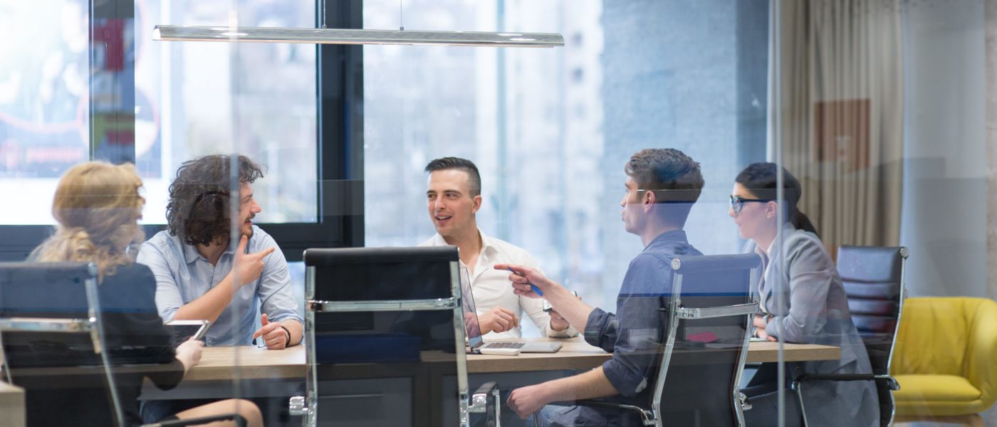 Group of a young business people discussing business plan at modern startup office building